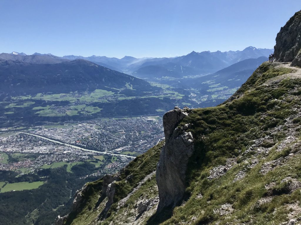 Auf dem Goetheweg im Karwendel wandern - links unten die Stadt Innsbruck, rechts der Weg mit den Wanderern