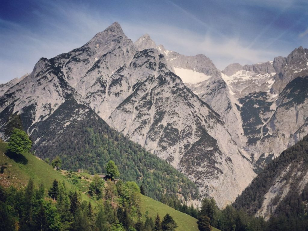 Einmalig schön: Die grüne Almwiese rund um die Alm, dahinter die schroffen Spitzen des Karwendel